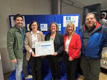 Auf dem Bild sind Bildungsminister Sven Teuber (links), Frau Konrektorin Sabine Hayer, Schulleiterin Elke Raetz, Landrätin Anke Beilstein sowie der UNESCO Landeskoordinator Matthias Erlei (rechts)